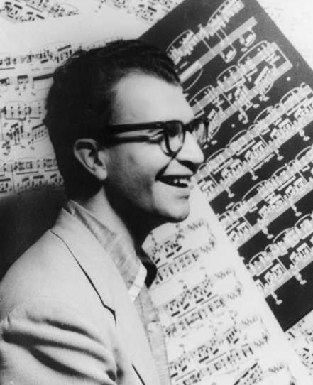 Dave Brubeck fotografiat de Carl Van Vechten în 1954, în fața unui fundal cu partituri.