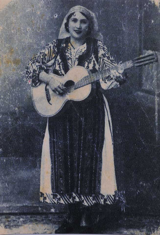 Maria Lătărețu at eighteen in 1929, holding a guitar and wearing traditional dress.