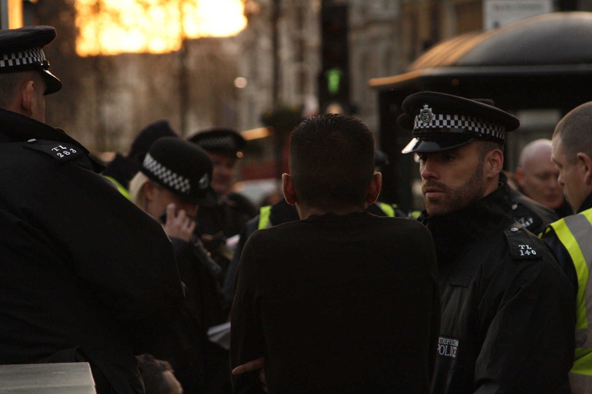 Doi polițiști Metropolitan Police discută cu un civil pe o stradă din Londra.