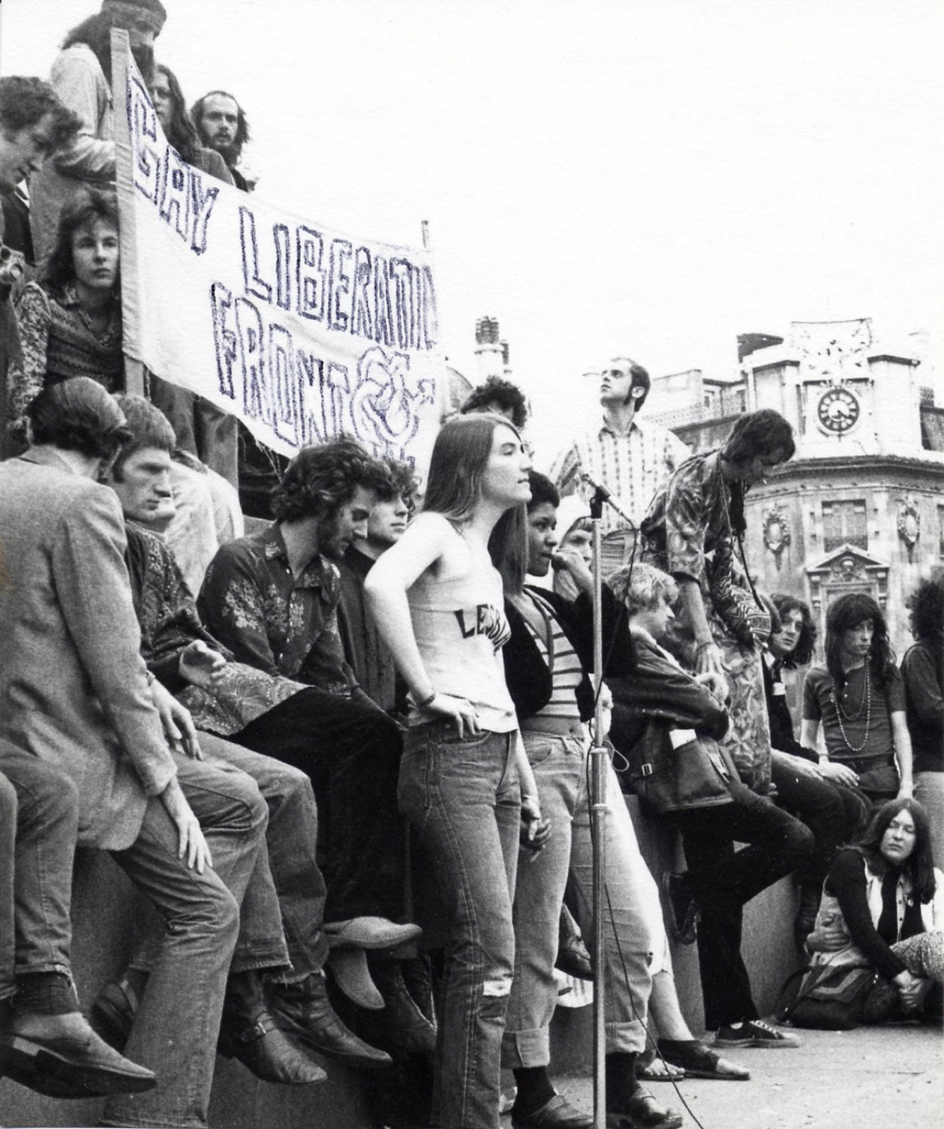 Membri și simpatizanți Gay Liberation Front la o manifestație din Trafalgar Square în 1971, în jurul unei pancarte „Gay Liberation Front”.