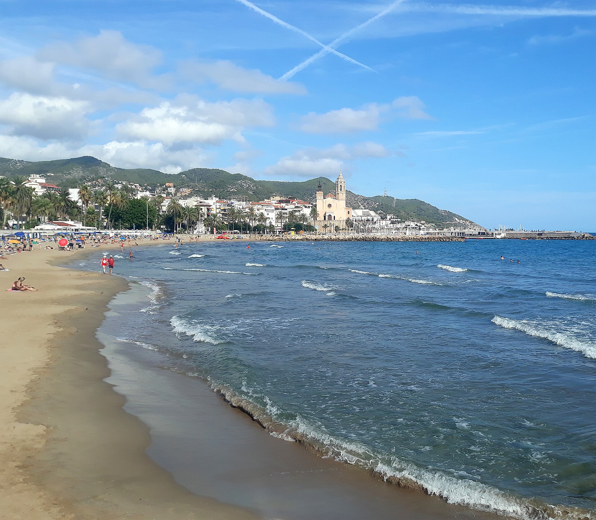 Plaja și centrul istoric din Sitges, cu biserica Sant Bartomeu i Santa Tecla deasupra mării.